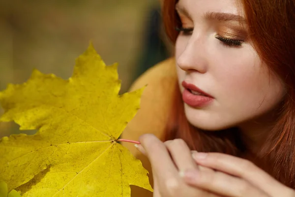 Frau mit gelben Ahornblättern im Herbst — Stockfoto