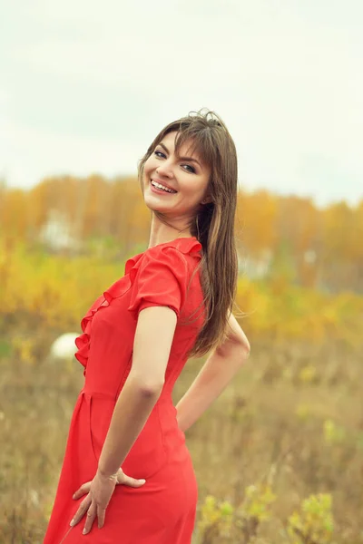 Осенний портрет красивой брюнетки среднего возраста женщины в красном платье — стоковое фото
