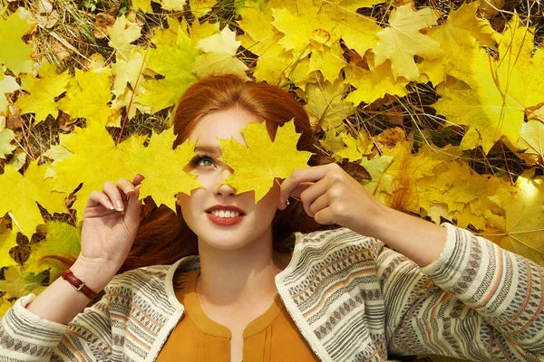 woman with yellow maple leaves in autumn