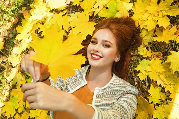 Frau mit gelben Ahornblättern im Herbst — Stockfoto