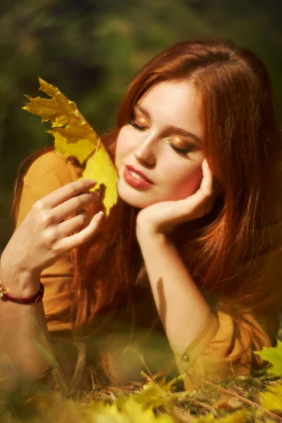 Woman with yellow maple leaves in autumn — Stock Photo, Image