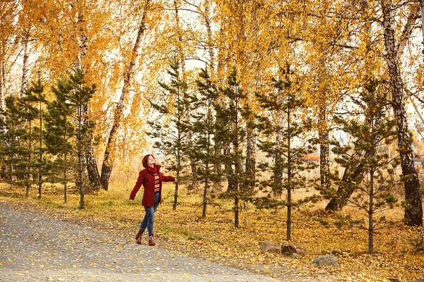 Frau mit gelben Blättern im Herbstpark. — Stockfoto