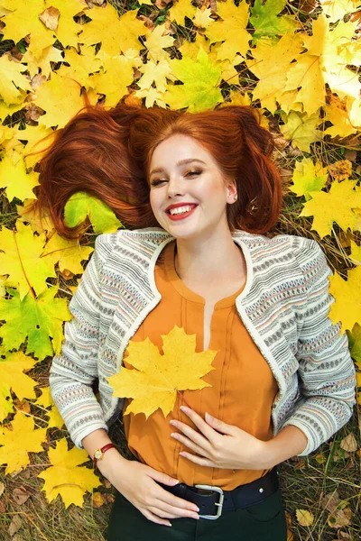 Donna con foglie di acero giallo in autunno Foto Stock