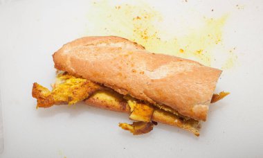 Beyaz arka plan üzerinde zerdeçal ile pişmiş sağlıklı tavuk göğsü sandviç.