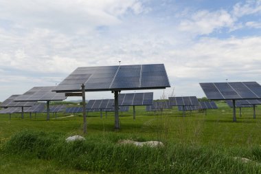 Güneş panelleri bir dizi bir çayır mavi ve bulutlu gökyüzü altında doldurun