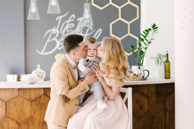 Güzel anne bir yaşındaki çocuklarının evde pastel renklerde güzel bir iç ile gülümse. Aile bak. Mutlu Doğum günü partisi