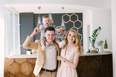 Güzel anne bir yaşındaki çocuklarının evde pastel renklerde güzel bir iç ile gülümse. Aile bak. Mutlu Doğum günü partisi