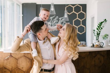 Güzel anne bir yaşındaki çocuklarının evde pastel renklerde güzel bir iç ile gülümse. Aile bak. Mutlu Doğum günü partisi