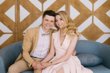 Güzel sevgi dolu genç çift evde güzel iç ve şık kıyafetler içinde gülümseme ve kameraya bak