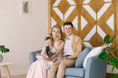 Bir yaşındaki çocuk önizleme albümü ile evde pastel renklerde güzel bir iç güzel anne gülümse. Aile bak. 