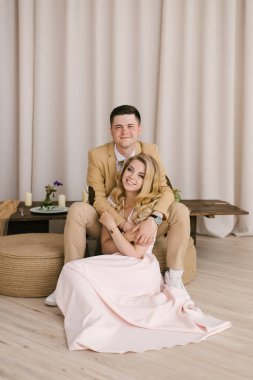 Güzel sevgi dolu genç çift evde güzel iç ve şık kıyafetler içinde gülümseme ve kameraya bak