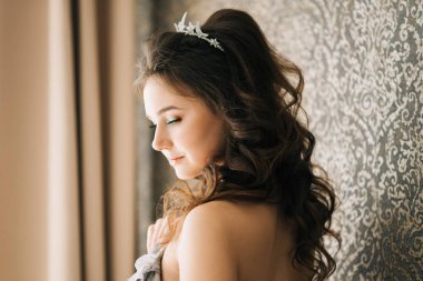 Bir gelinlik pencerenin yakınındaki bir sevimli gelin portresi. Düğün sabah