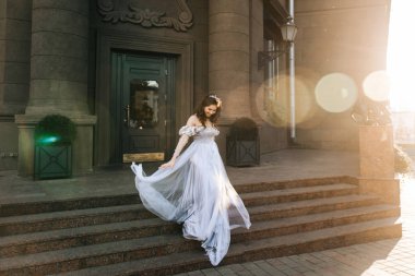 Beyaz mutlu romantik gelin Avrupa'nın şehir etrafında yürür. Düğün kavramı. Güzel güneş ışığı