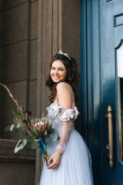 Beyaz mutlu romantik gelin alışılmadık bir buket ile Avrupa'nın şehir etrafında yürür. Düğün kavramı.