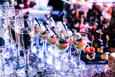 Aperatifler ve ziyafet düğün için şampanya ile lezzetli bir şekilde dekore edilmiş bar. Tatlı yeni evliler ve misafirler için alışılmadık bir resepsiyon