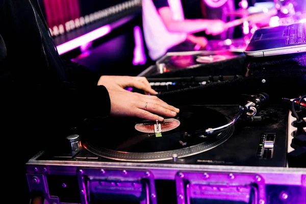 Party dj plays music at hip hop concert.Turntables vinyl record player.Retro analog audio equipment for disc jockey scratching records.Cut tracks with cross fader knob on sound mixer.Stage equipment