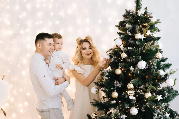 新年的画像是一个美丽的年轻家庭 有吸引力的父母和一个小儿子装饰圣诞树 — 图库照片