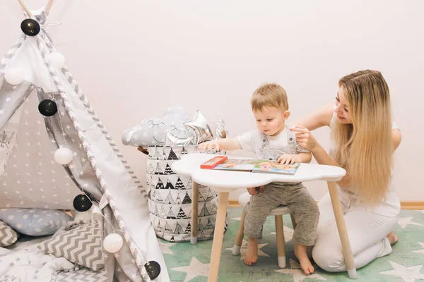 Cute Baby Sitting Table Reading Book His Mother Nursery Bright — Stock Photo, Image