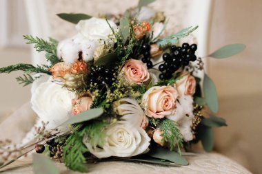 Pastel kış gelinin buket gül, Ladin, pamuk, siyah meyveleri, tüyler ve Kuru çiçekler ile rustik renkler. Seçici odak