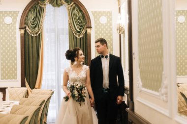 Mutlu genç ve sevgi dolu gelin ve damat bir lüks otel ziyafet salonuna git. Düğün günü