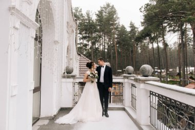 Gelin ve damat güzel bir otel balkonunda mutlu genç aşıkların portresi. Düğün günü