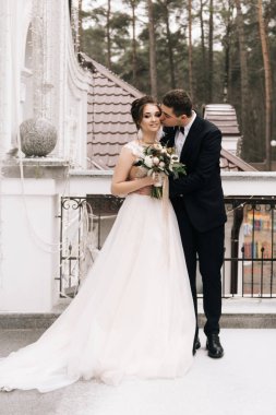 Gelin ve damat güzel bir otel balkonunda mutlu genç aşıkların portresi. Düğün günü