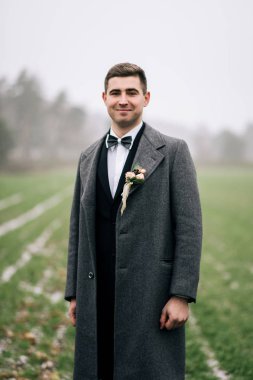 Şık düğün mamülleri fotoğraf. Güzel zarif damat düğün günü açık havada. Düğün kış