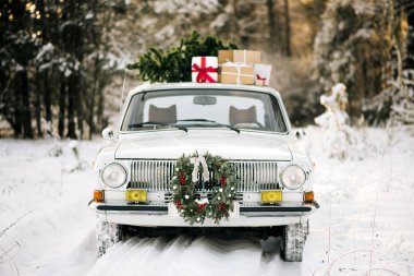 Hediyeler ve Noel ağacı karlı kış orman ve güzel Noel çelenk ile Retro araba. Tatil dekorasyon, Noel Baba teslim