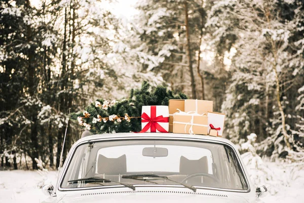 Hediyeler ve Noel ağacı karlı kış orman ve güzel Noel çelenk ile Retro araba. Tatil dekorasyon, Noel Baba teslim