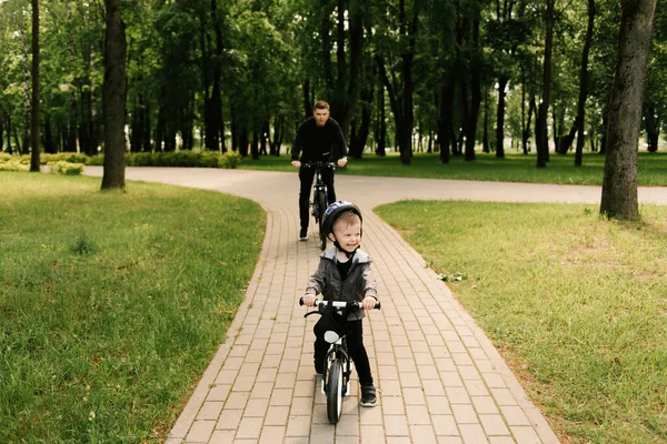 Szczęśliwy Mały Chłopiec Jeździ Rowerze Młodym Tatą Parku — Zdjęcie stockowe