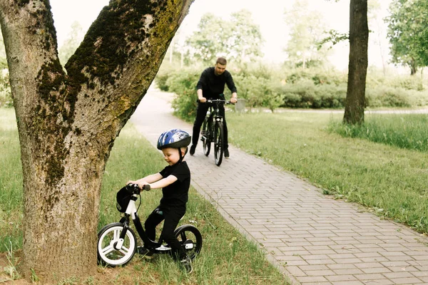 Happy Little Boy Rides Bike Young Dad Park — Stock Photo, Image