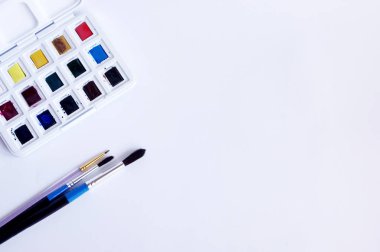 suluboya beyaz arkaplanda boya ve fırçalar.