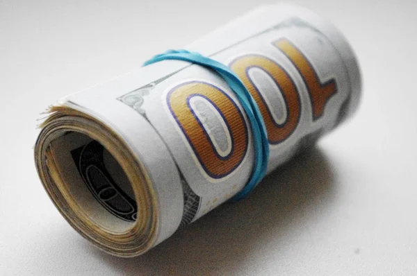 Roll of dollars gebonden met rubber band op witte achtergrond. — Stockfoto