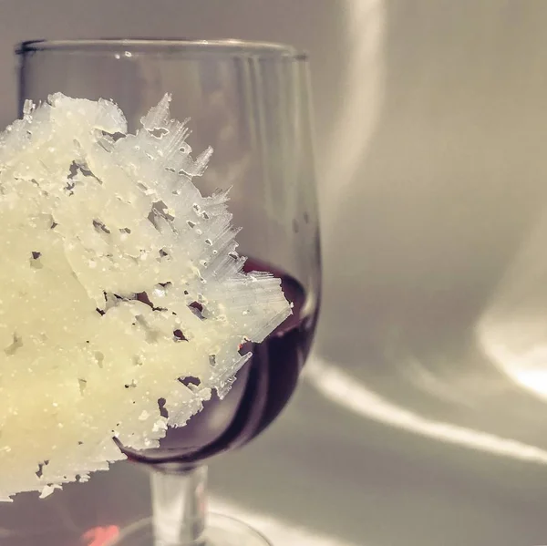 Un bicchiere di vino rosso e un sottile pezzo di formaggio — Foto Stock