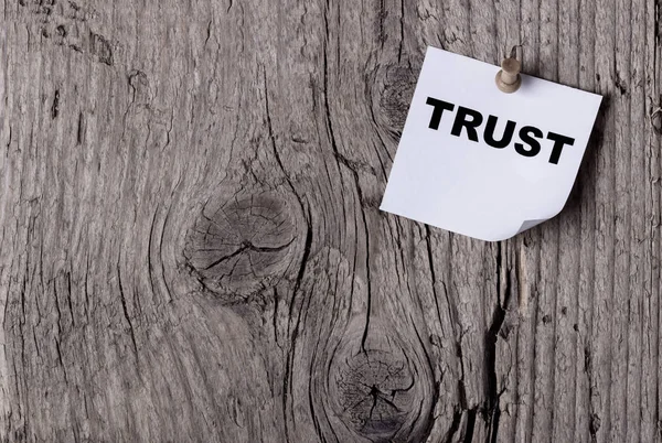 Bir kelime güven ahşap panosuna iğnelenmiş kağıt üzerinde yazılı