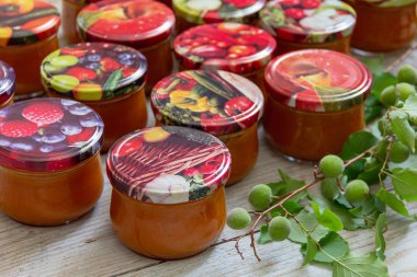 ahşap bir masa üzerinde evde hazırlık sürecinin taze kayısı ile cam kavanoz reçel