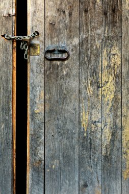 Eski ortaçağ kapısı aralık ve zincir ve asma kilit ile kilitlenmiş.