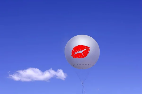 White balloon with printed red lips against blue sky and cloud