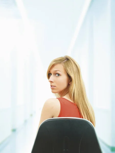 blonde Young woman sitting on chair,