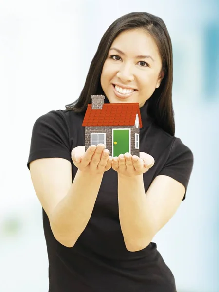 Joven Mujer Sosteniendo Miniatura Casa Modelo Figura Sonriendo — Foto de Stock