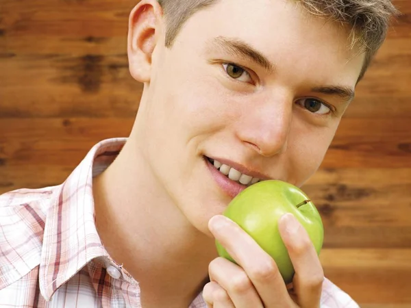 Tonåring Pojke Innehar Grönt Äpple Vid Munnen Och Ler Kamera — Stockfoto