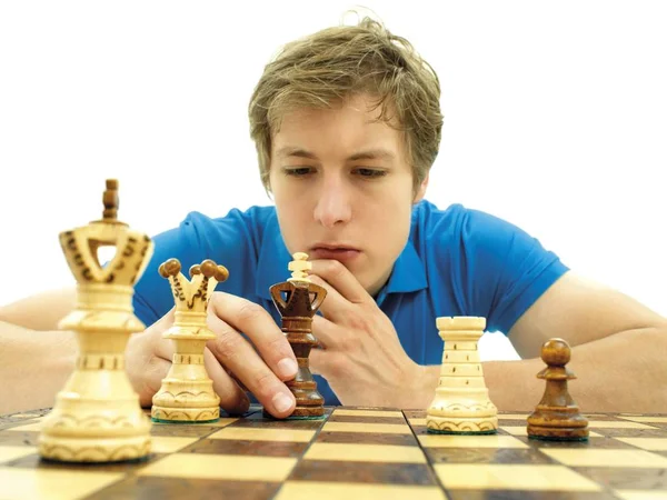 Young man playing chess, concentrating at chess board