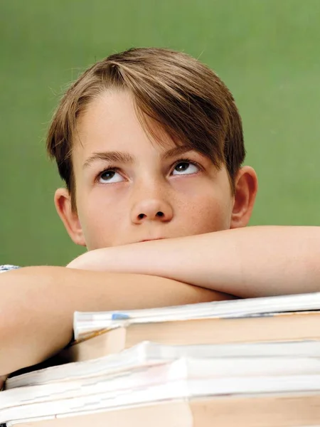 Шкільний Хлопчик Перед Шкільною Дошкою Стопкою Книг Виглядає Розчарованим Втомленим — стокове фото