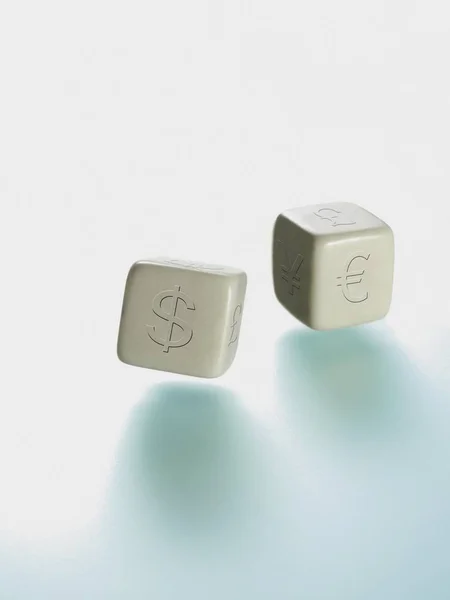 Two dice with currency symbols, euro, dollar, pound, yen