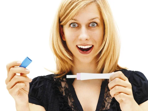 surprised happy blonde Woman holding a pregnancy test