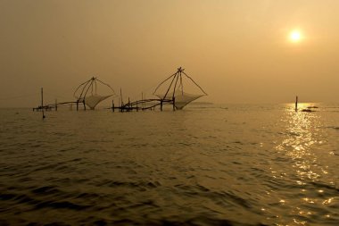 Chinese fishing net in ocean water at sunrise, Vembanad lake, Kerala, India, Asia clipart