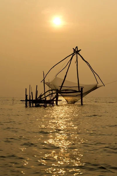 Chinese fishing net in ocean water at sunrise, Vembanad lake, Kerala, India, Asia