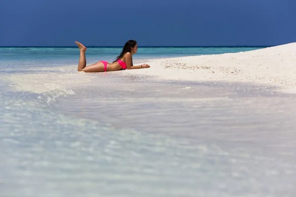 Woman in a pink bikini lying on the beach, Male, North Male Atoll, Maldives, Asia