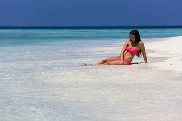 Woman in a pink bikini lying on the beach, Male, North Male Atoll, Maldives, Asia