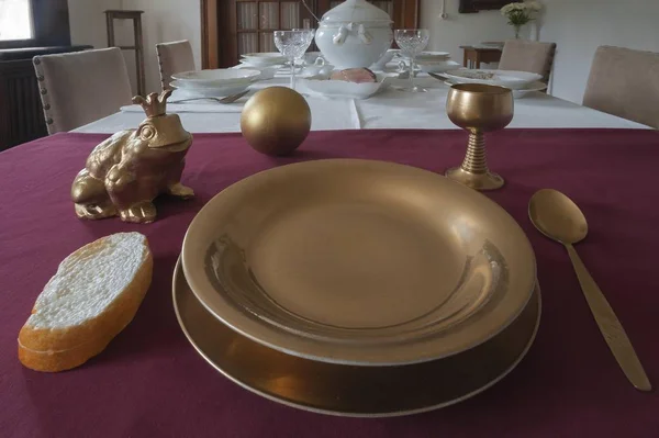 Frog next to a golden plate on the table, depiction from the fairy tale The Frog Prince, \